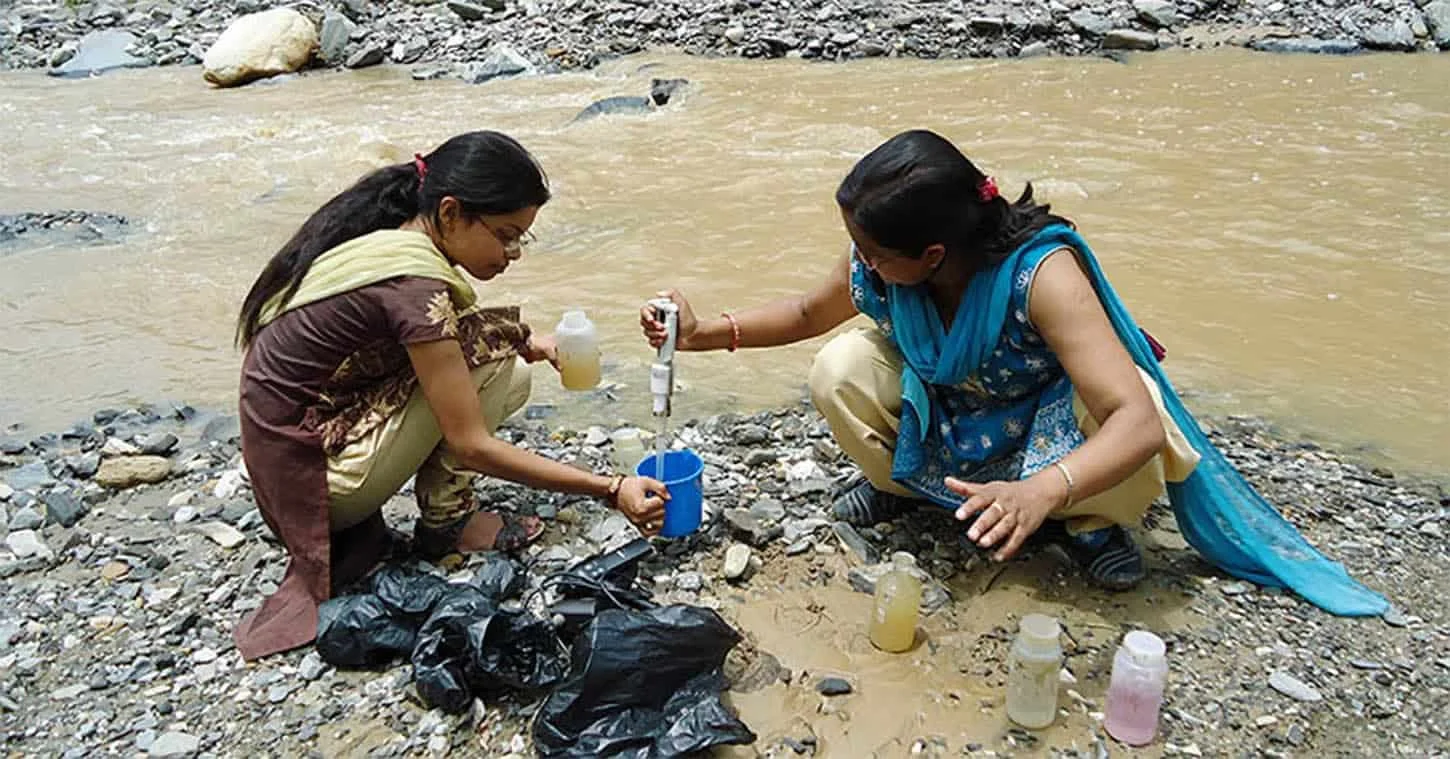 Tista and researcher in a riverside conducting research to water