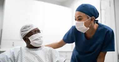 nurse with patient, both wearing masks