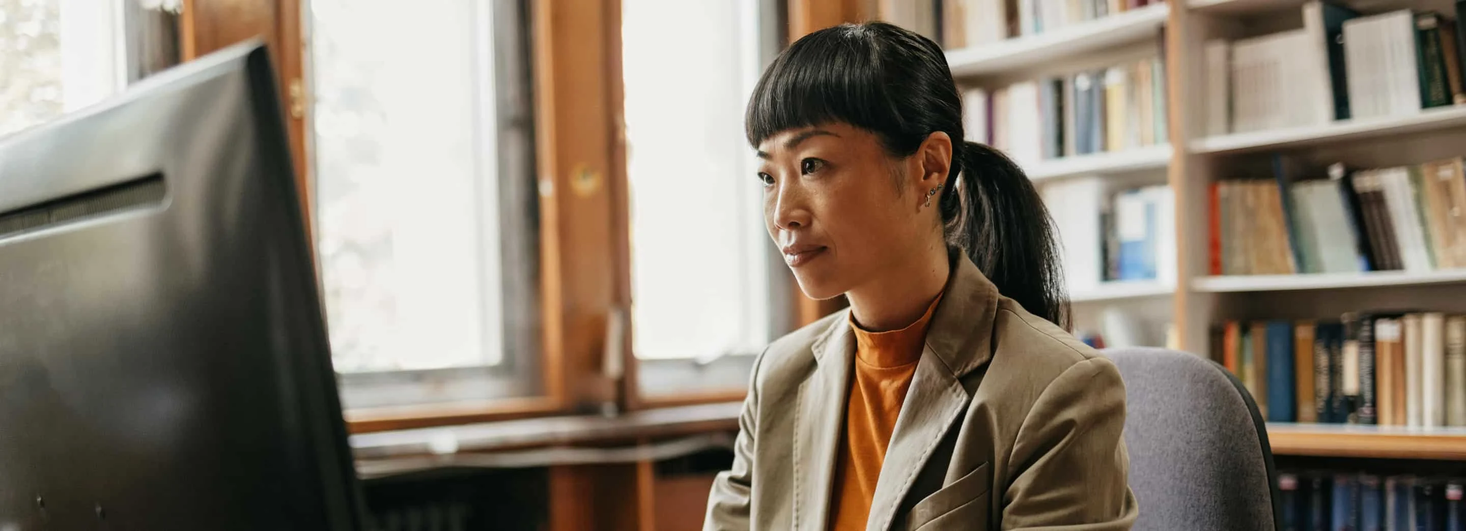 Librarian sitting in office working on laptop