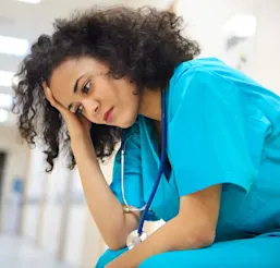 Nurse with head in hand