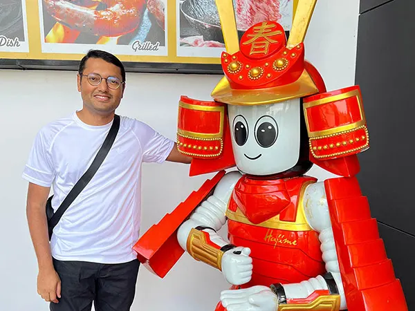 HM Kamrul Hassan poses with a humanoid at Hajime Robot Restaurant in Bangkok, Thailand