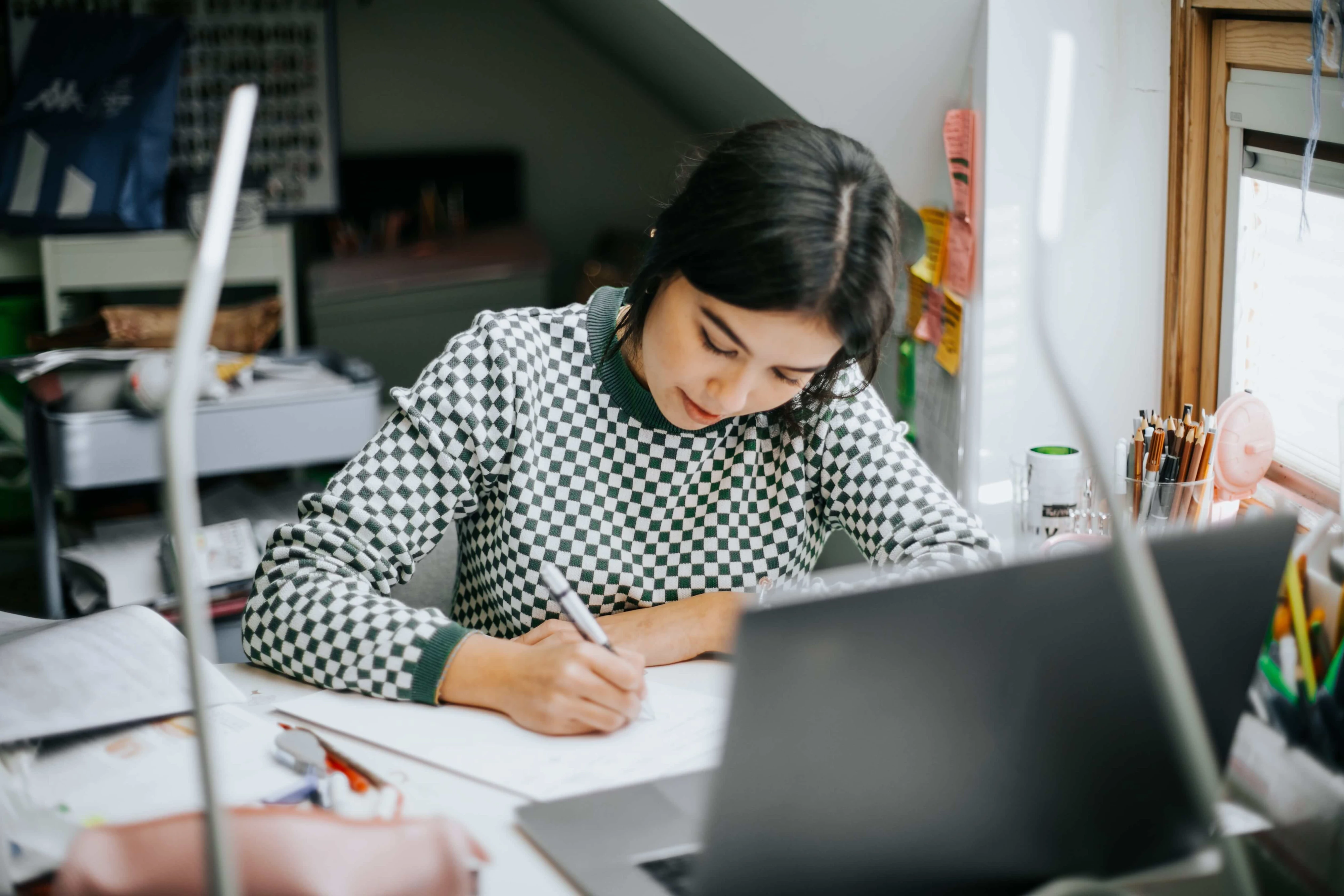 hispanic college student doing some home works from home with laptop