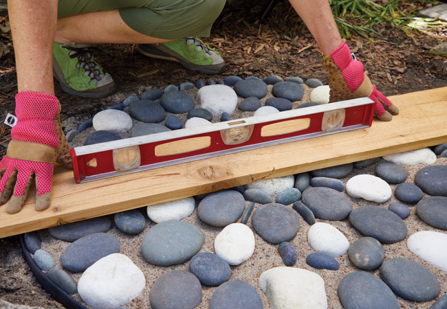 mosaic stepper leveling: Level the tops of all stones to avoid tripping along the path.