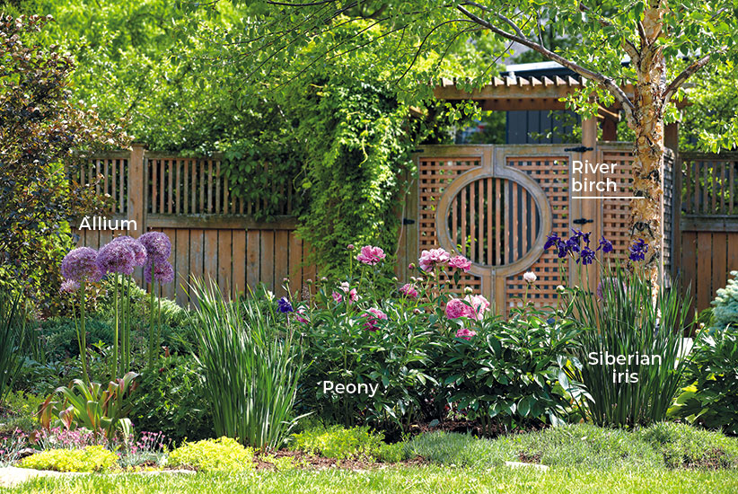 6-ways-to-create-a-beautiful-spring-garden-add-structure-labeled: Plants come in different shapes and sizes. Take advantage of this to add interest. In this garden, upright allium and Siberian iris are exclamation marks among the other more mounding forms.