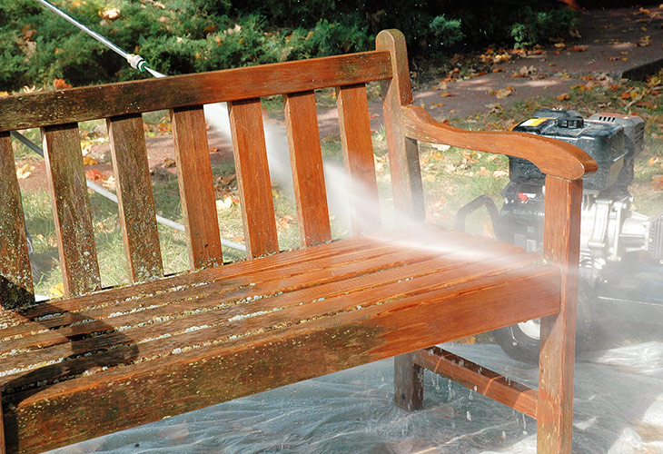 Power washing a wooden garden bench: Use a power washer to remove the rest of the wood brightening solution.