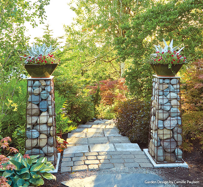 Stone Gabion pillars Camille Paulsen garden: Each gabion pillar is topped with a 12-inch square tile that holds a 20-inch container filled with annuals.