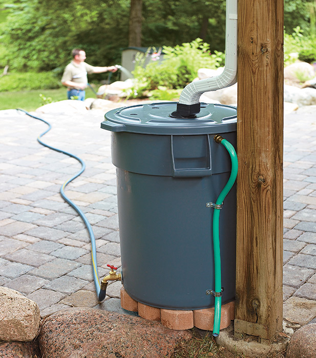 DIY Rain barrel made out of a heavy-duty trash can: Build a DIY rain barrel to save money on watering your garden.