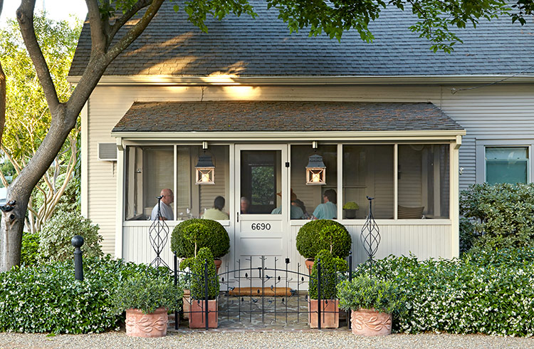 cozy-garden-lead: Just a handful of containers makes a big impact in a small space. Flanking the sidewalk with topiaries in containers calls attention to the front door.