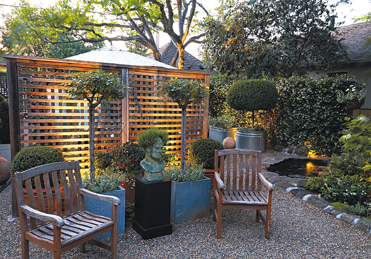 cozy-garden-seating-area-in-the-evening: Hide the light fixtures behind furniture, containers or other plants to keep the focus on what the light reveals instead of the fixture.
