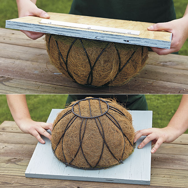 flipping-basket-plywood: Postion the painted frame board on the basket and flip it over so it lays flat.