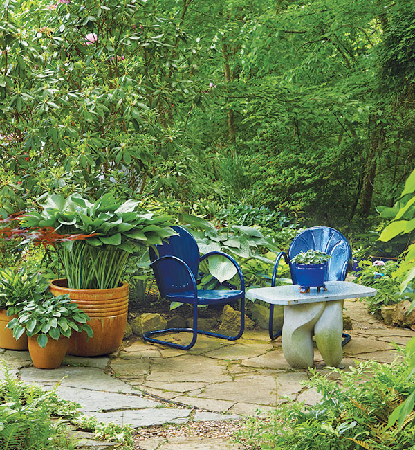 Shade garden seating area with blue chairs: To create a relaxing mood choose cool colors for your shady patio. Warm tones, such as red, orange and yellow, will add a more energy.