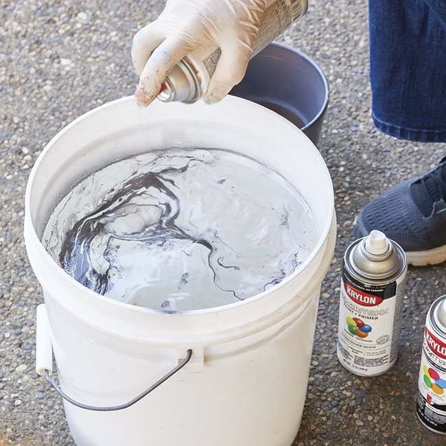 spray-surface-with-paint: Work quickly spraying layers of paint onto the surface of the water.