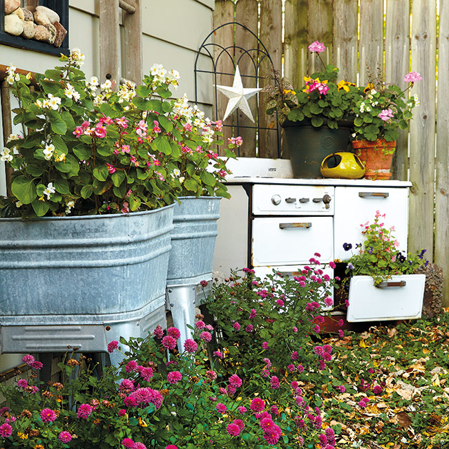 Upcycled wash bins and vintage stove for garden art and planting: Easy-to-grow wax begonias (Begonia semperflorens) fill up these old wash tubs. For just a few dollars, you can pick up a couple packs of plants at the garden center and have flowers from spring through frost.
