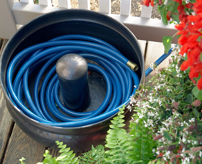 good-way-to-store-hose:This decorative hose holder keeps the hose under control and looks good, too. Some styles come with a lid, so they can sit out near the faucet without filling with rain water.