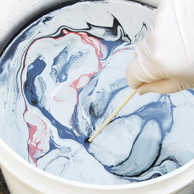marbleize-surface-with-skewer: Swirl the paint colors together with a skewer to achieve a marbled effect.