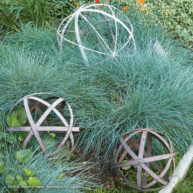Adding-structure-to-your-garden-using-unique-objects: In among this airy grass, these metal orbs take on even more interest than they might set in any other garden spot. And a grouping makes a bigger impact than one alone would. 