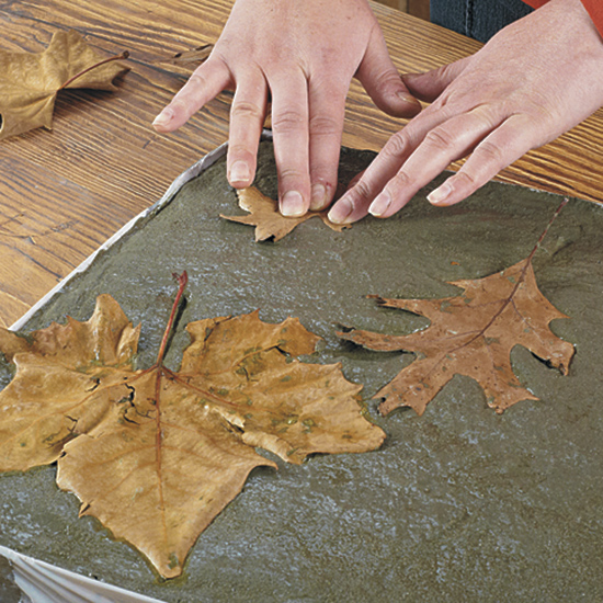Press leaves into concrete: Use a variety of leaf shapes and sizes to add variety and interest to the design.