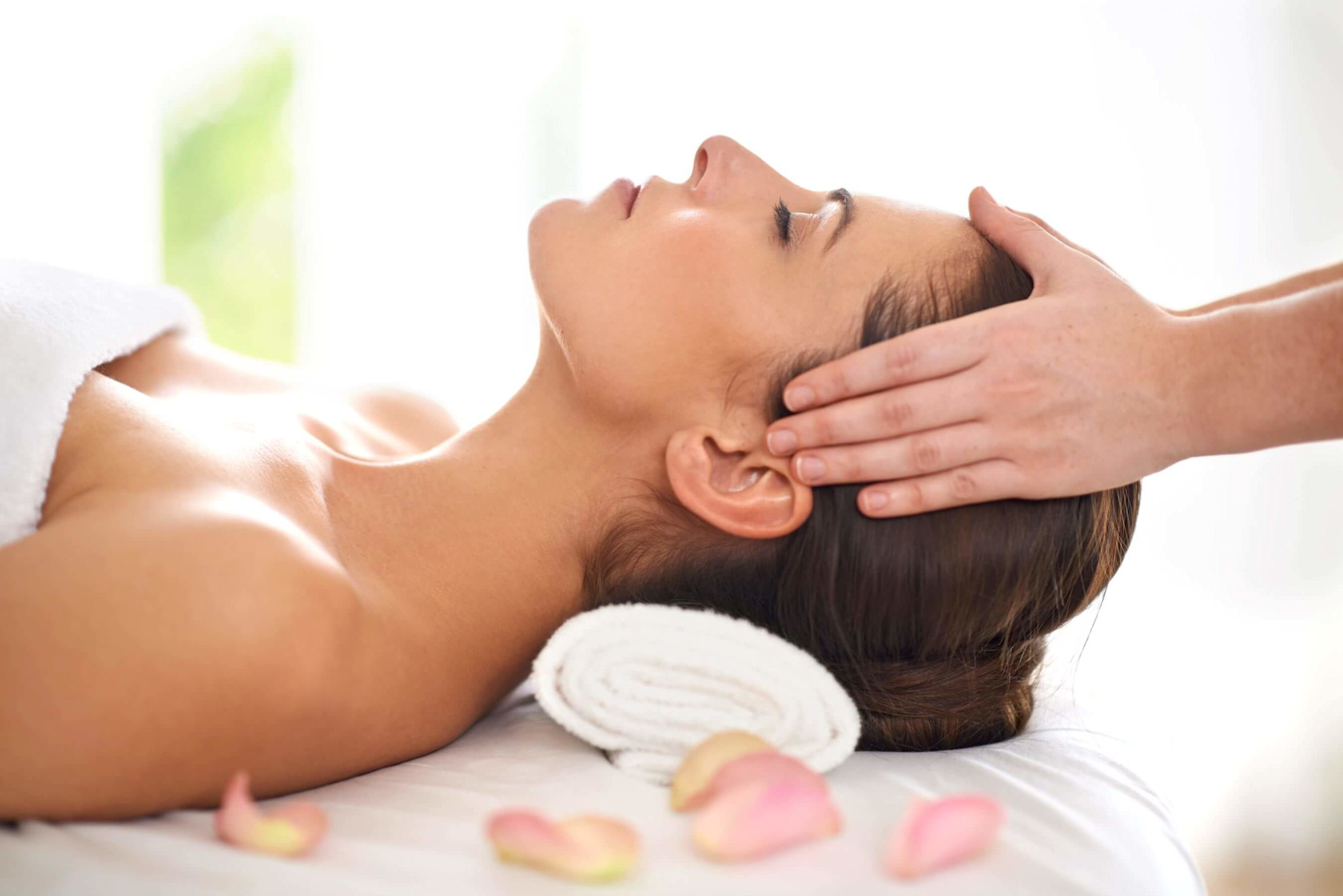 Young woman receiving a head massage at a spa