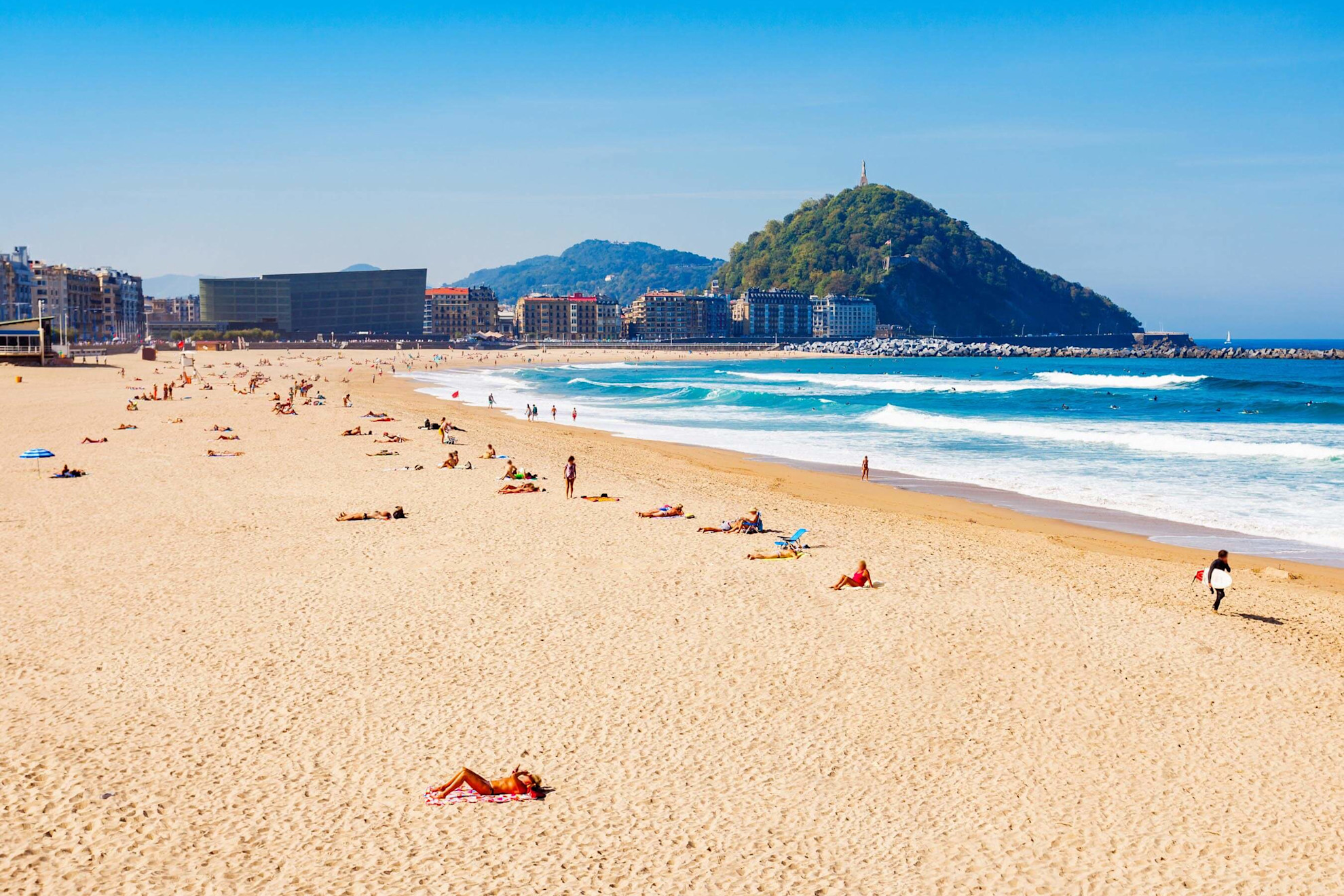 The golden sands of Zurriola beach beside Mount Urgull