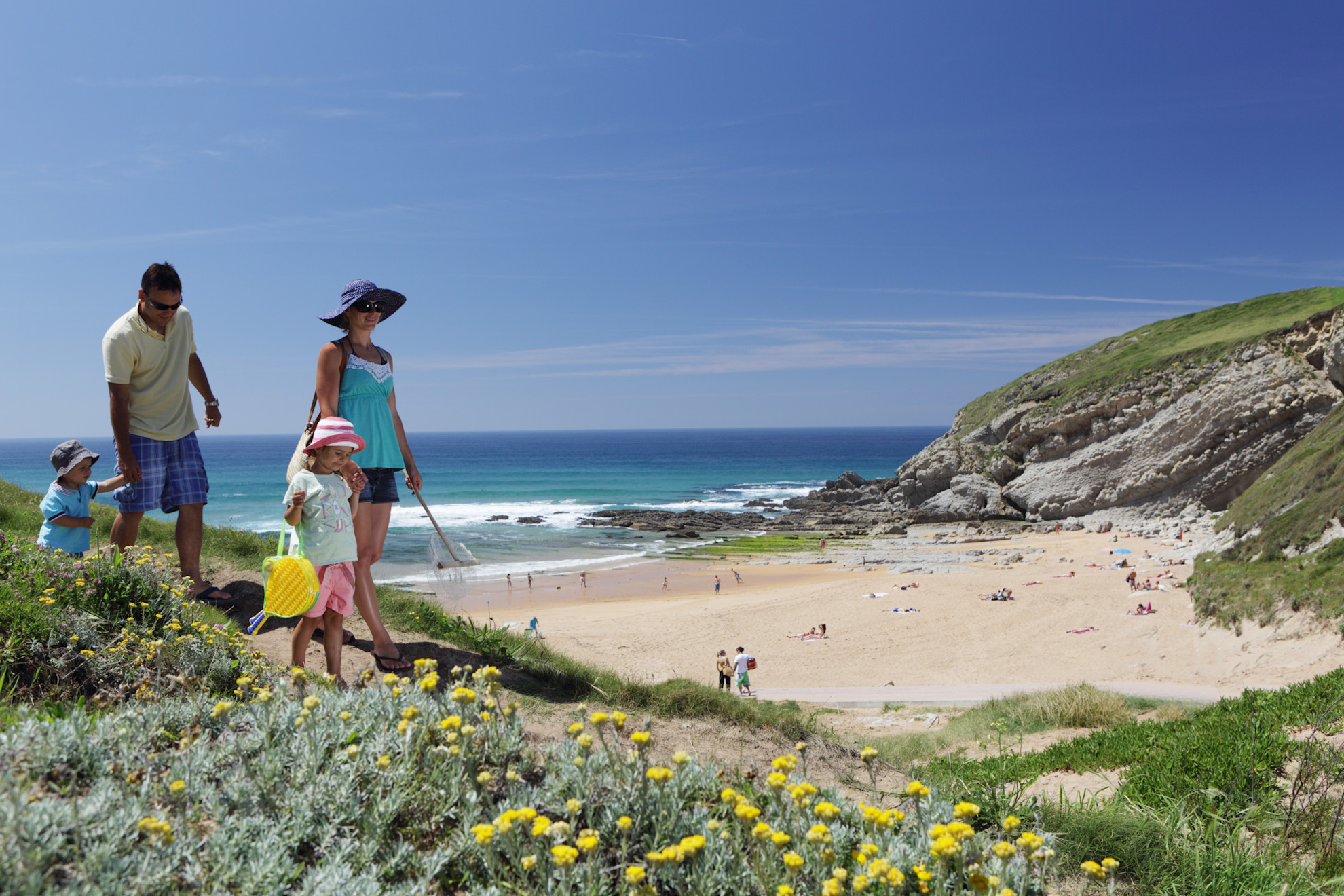 Family walking down to beach in northern Spain