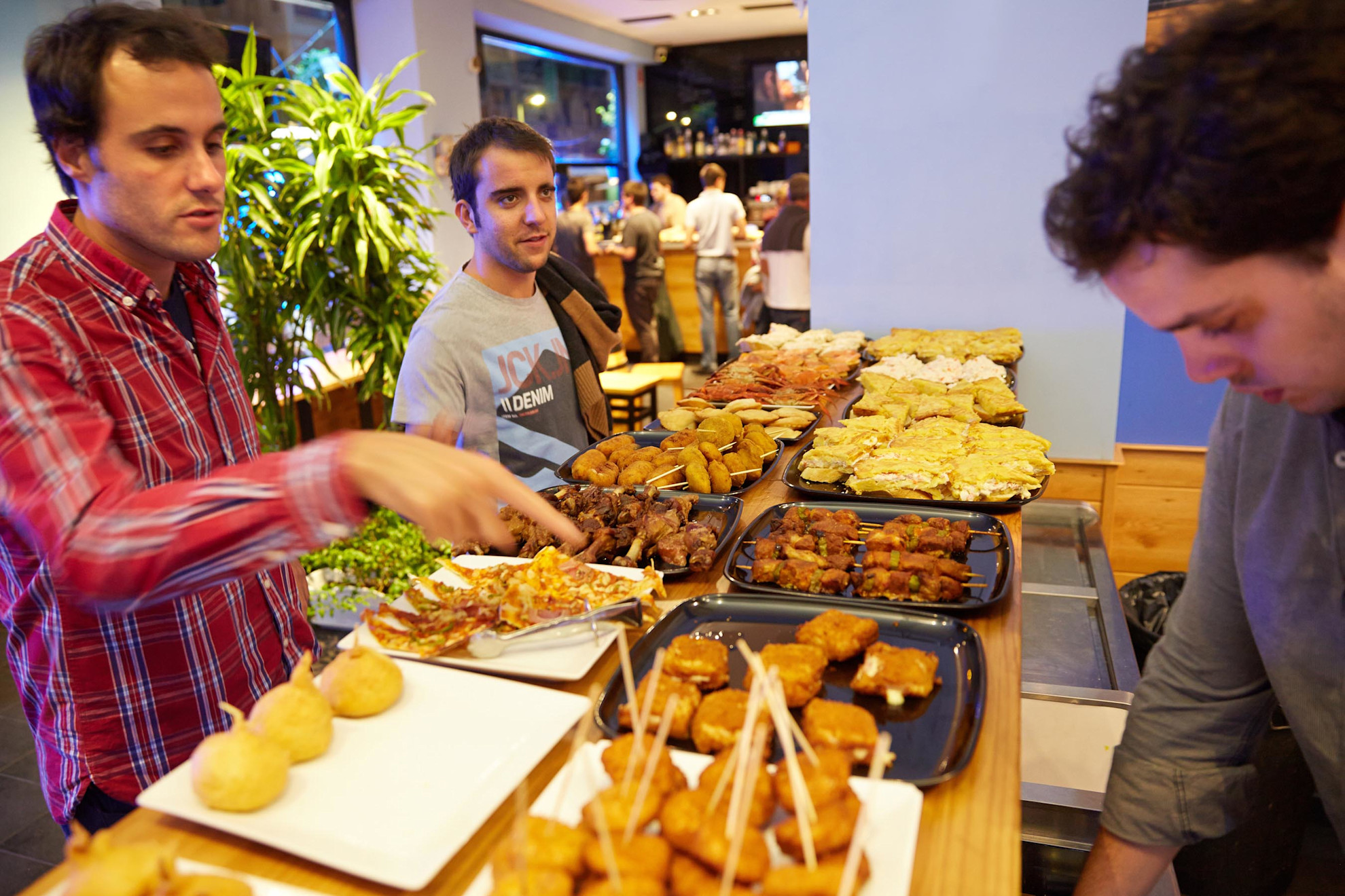 People selecting their pintxos at the bar