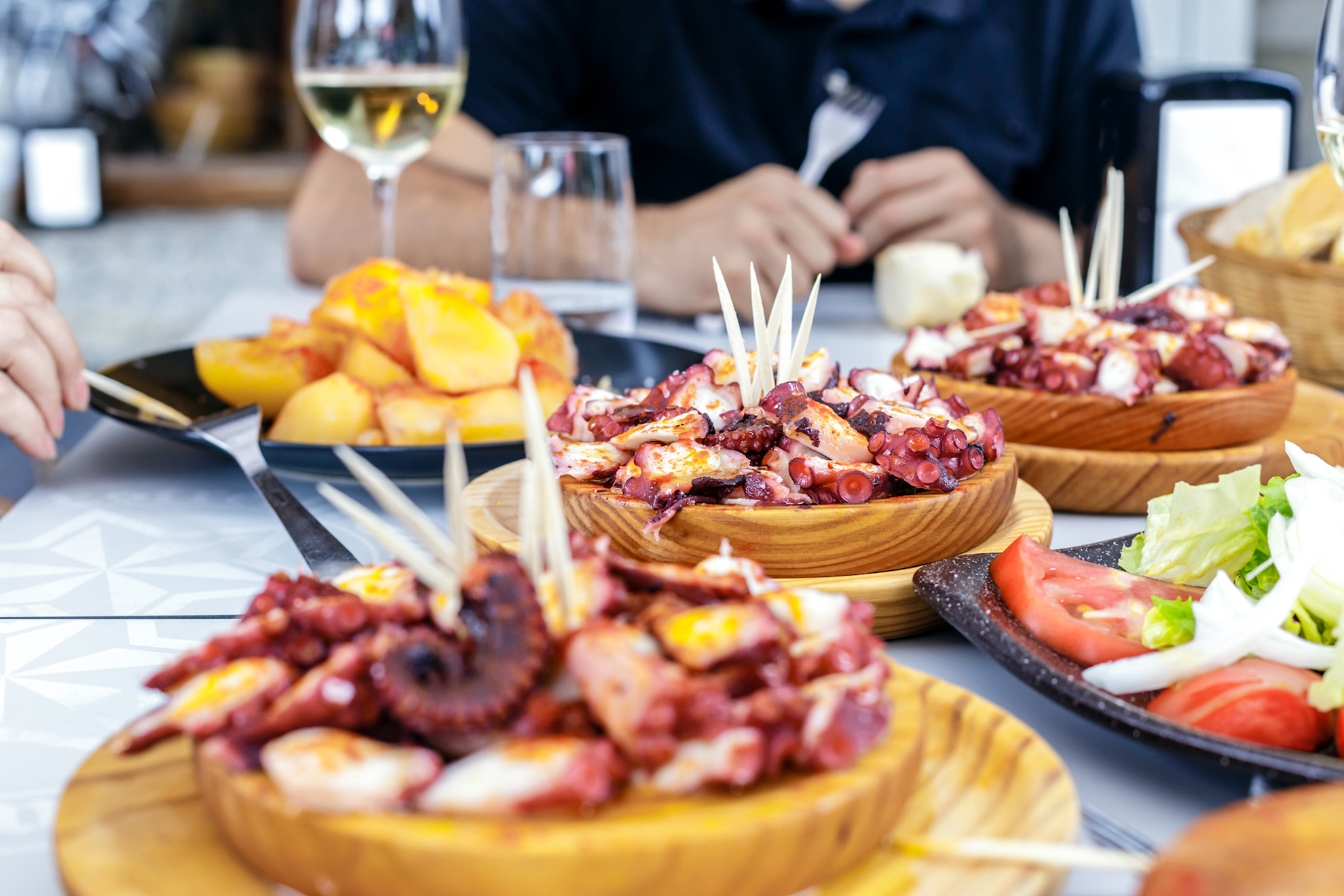 Dinner table with plates of pulpo á fiera © Shutterstock