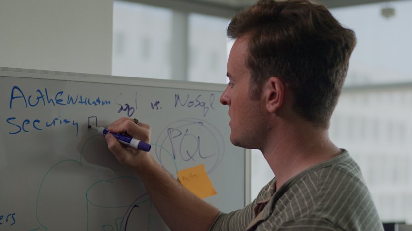 Alex Monroe working at a whiteboard in the Celonis LA office.