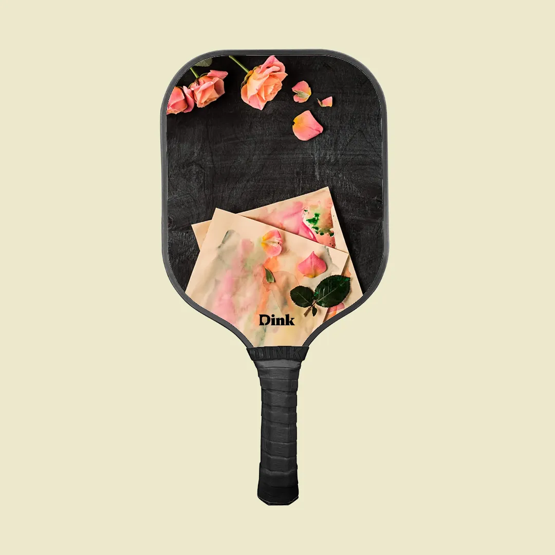 A custom pickleball paddle from Dink with a watercolors, drawings and roses design