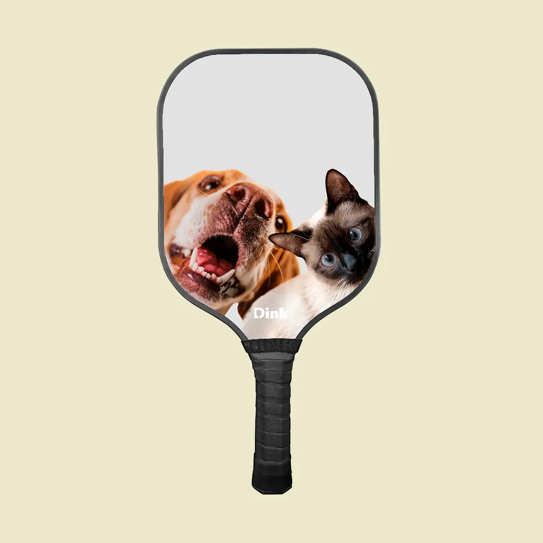 A custom pickleball paddle from Dink with a cute dog and cat design