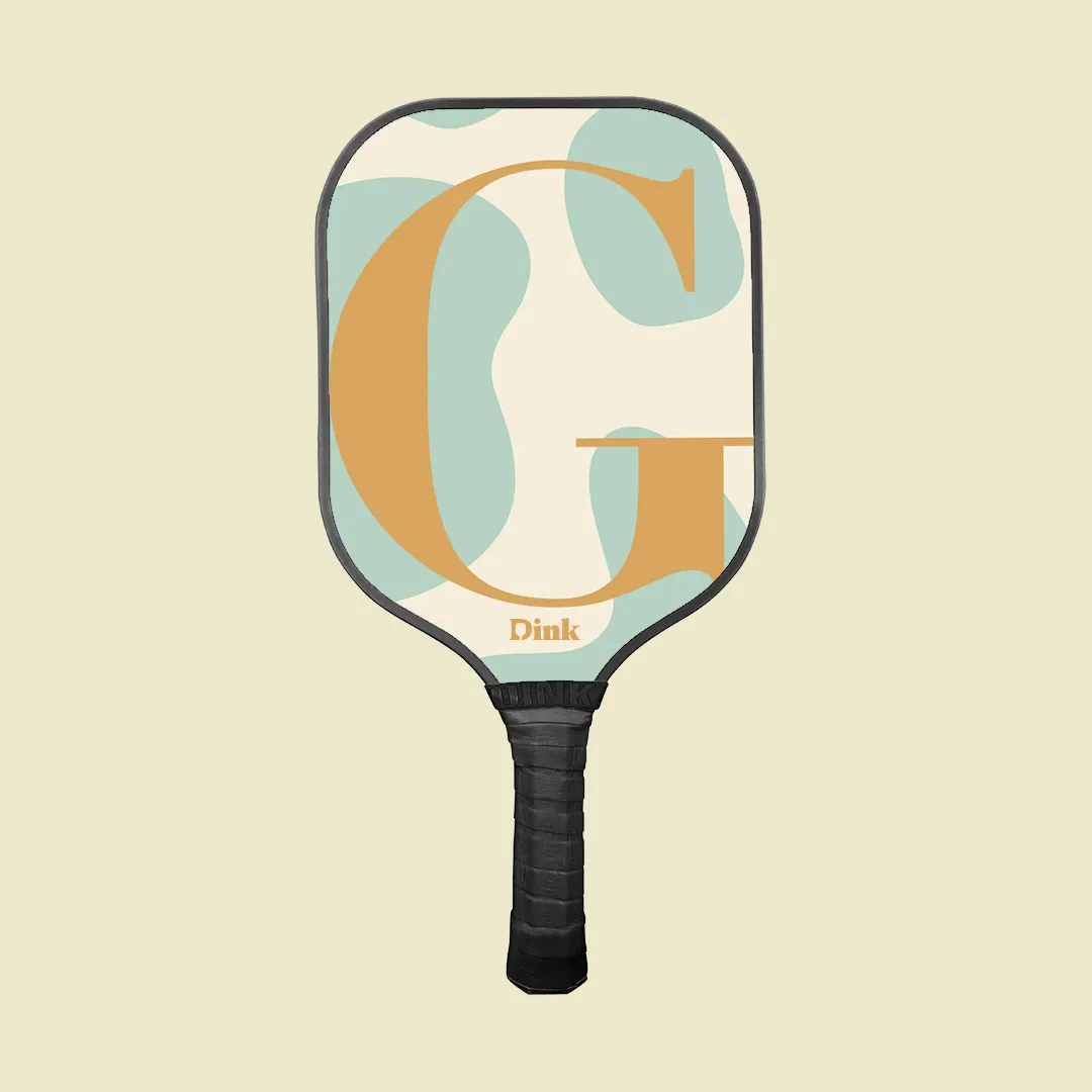A custom pickleball paddle from Dink with a an elegant blue yellow initials design.