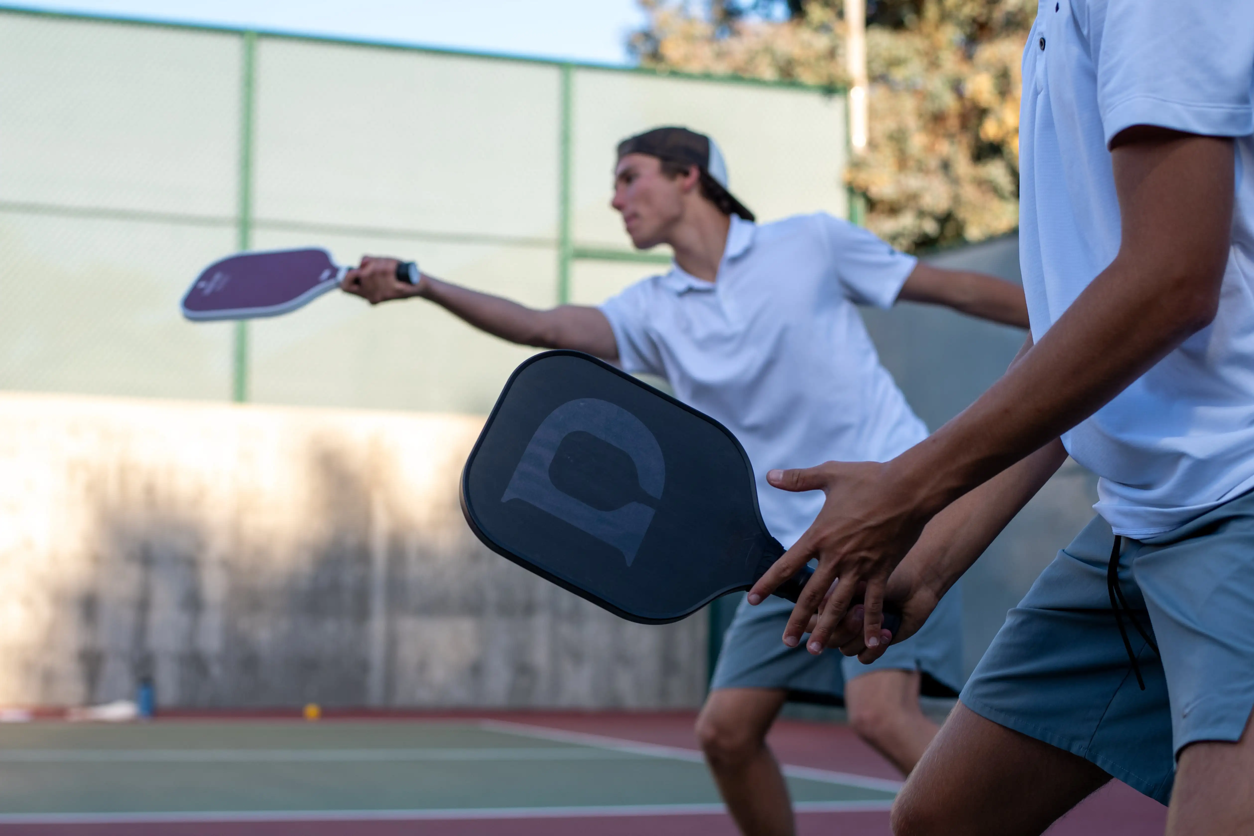 Two men pickleball players playing pickleball doubles with Dink´s custom pickleball paddles