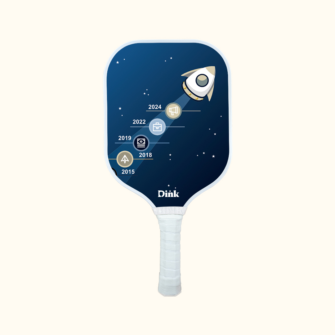 A rocket with company milestones dates on Dink custom pickleball paddle