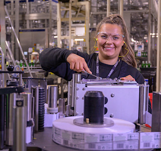 A woman in a factory working at some machinery.