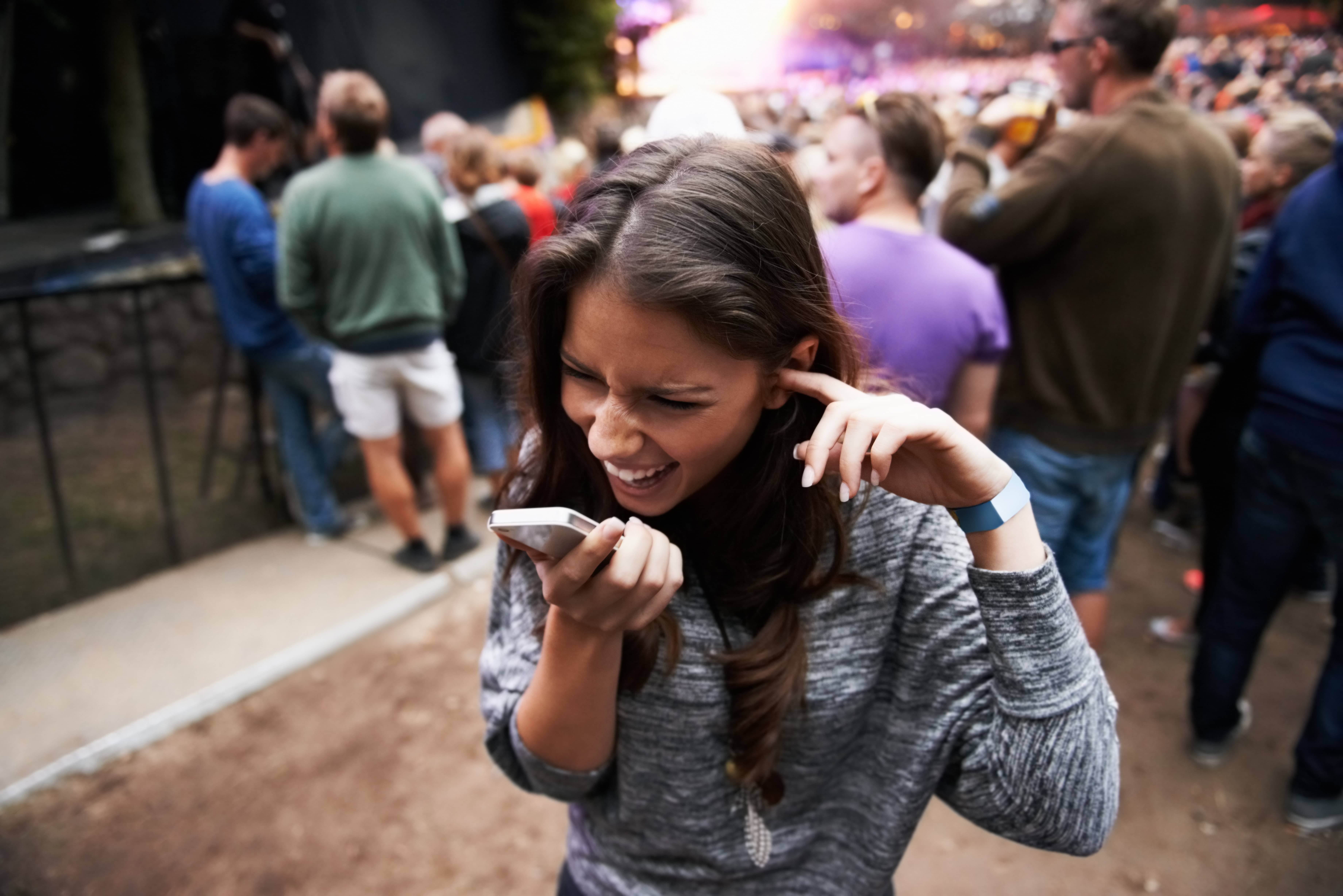 Person talking on the phone in a crowd.