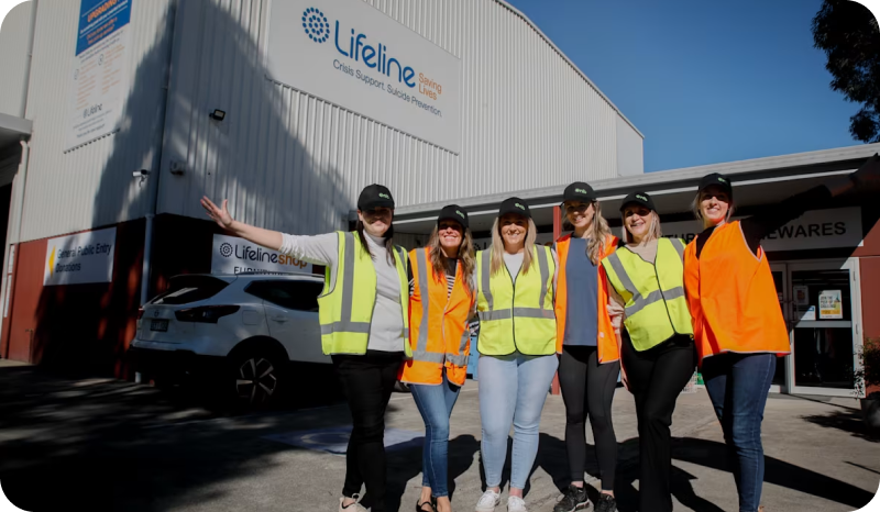 Group of nib employees volunteering at Lifeline Australia, wearing yellow and orange hi-vis and hats