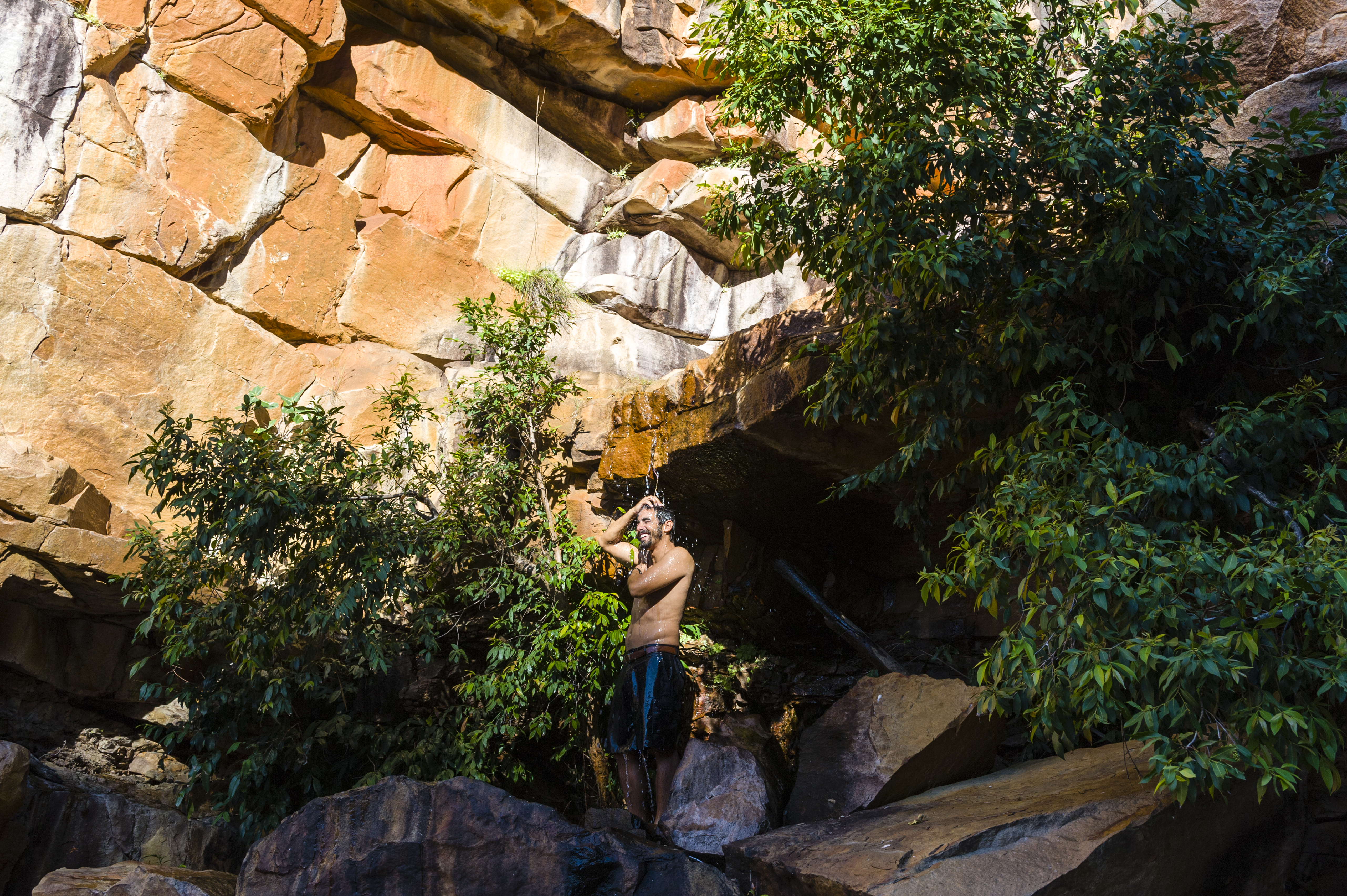Young male bushwalker with his shirt off after a swim in a freshwater creek.