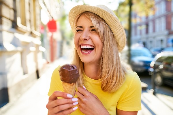 A smiling woman holding a chocolate ice cream