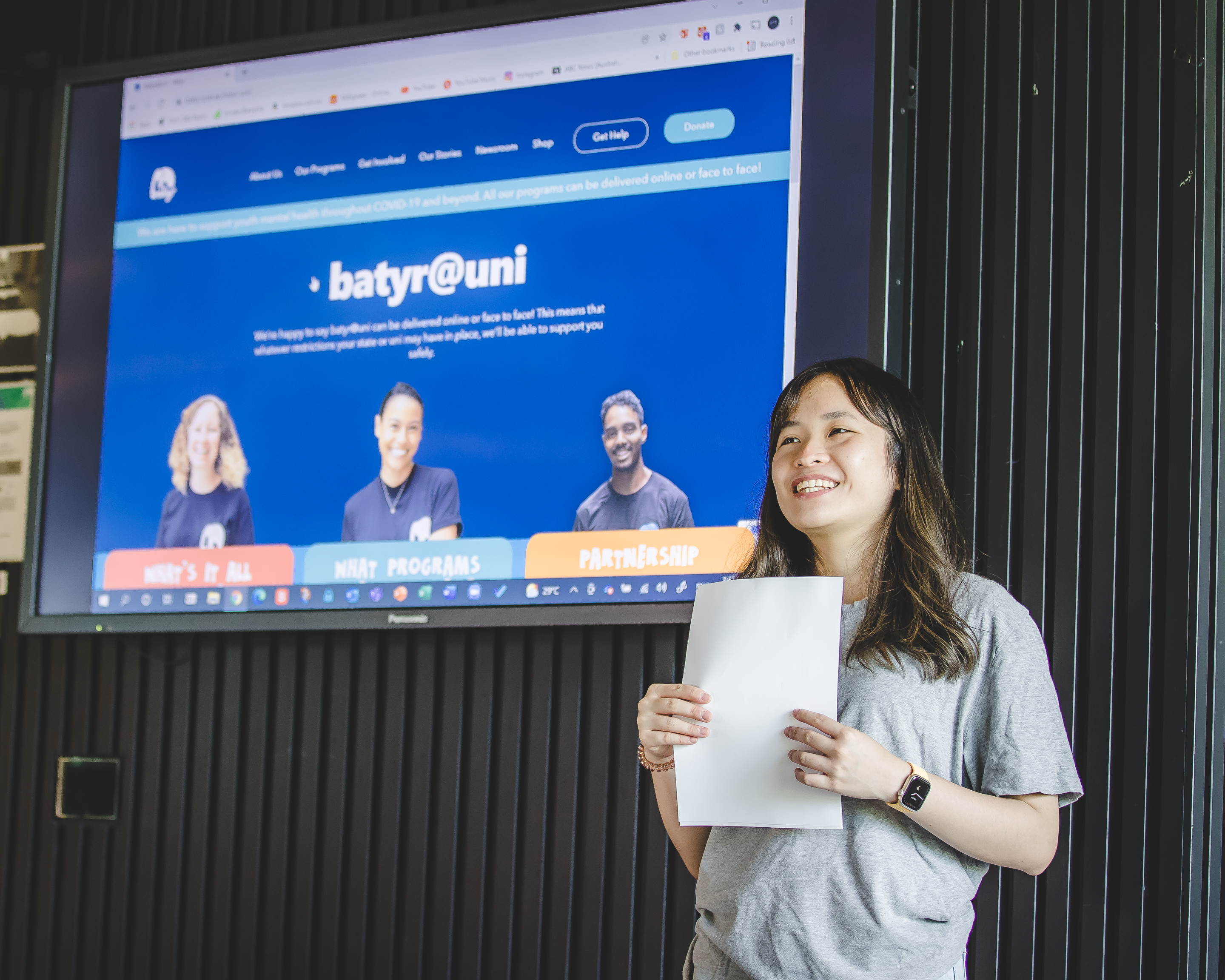 Image of Linh presenting and holding a paper