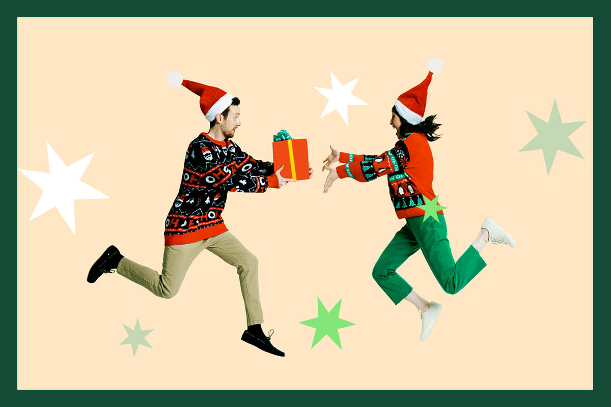 Man and woman wearing Santa hats jumping for joy. Man holding a gift and woman has hands outstretched to the gift