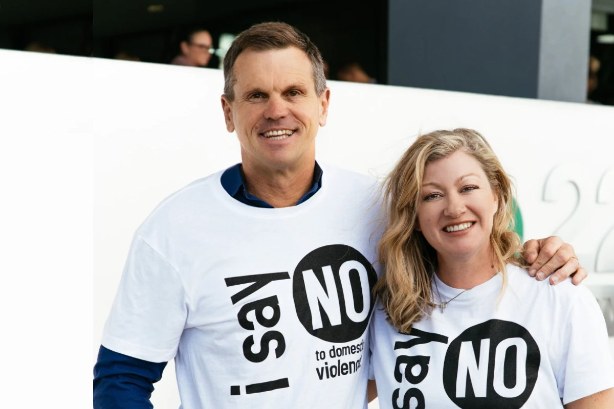 Two adults wearing 'I Say No to Domestic Violence' shirts