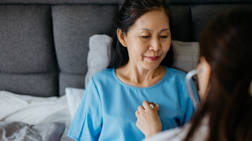 A woman having her heart rate checked by a doctor