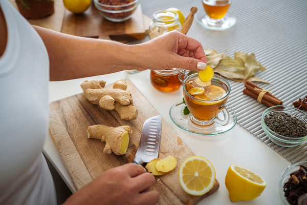 Person making a tea with ginger and lemon.