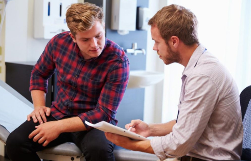 Man wearing red plaid shirt at the GP office