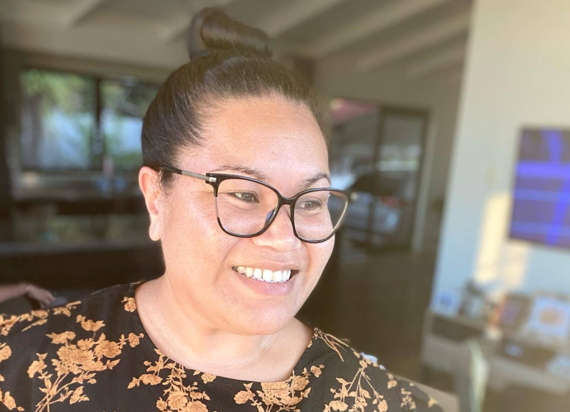 A close up of a smiling woman in glasses