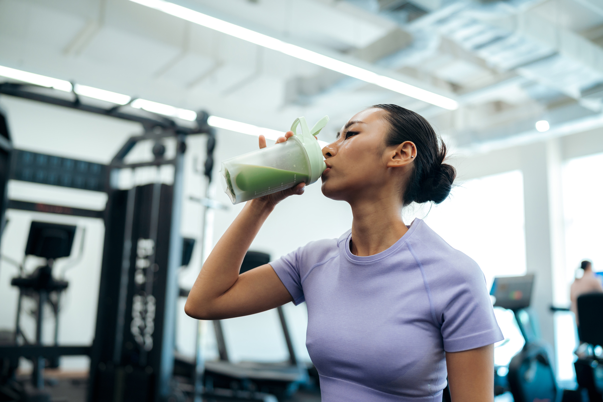 Person drinking a supplement shake during a workout.