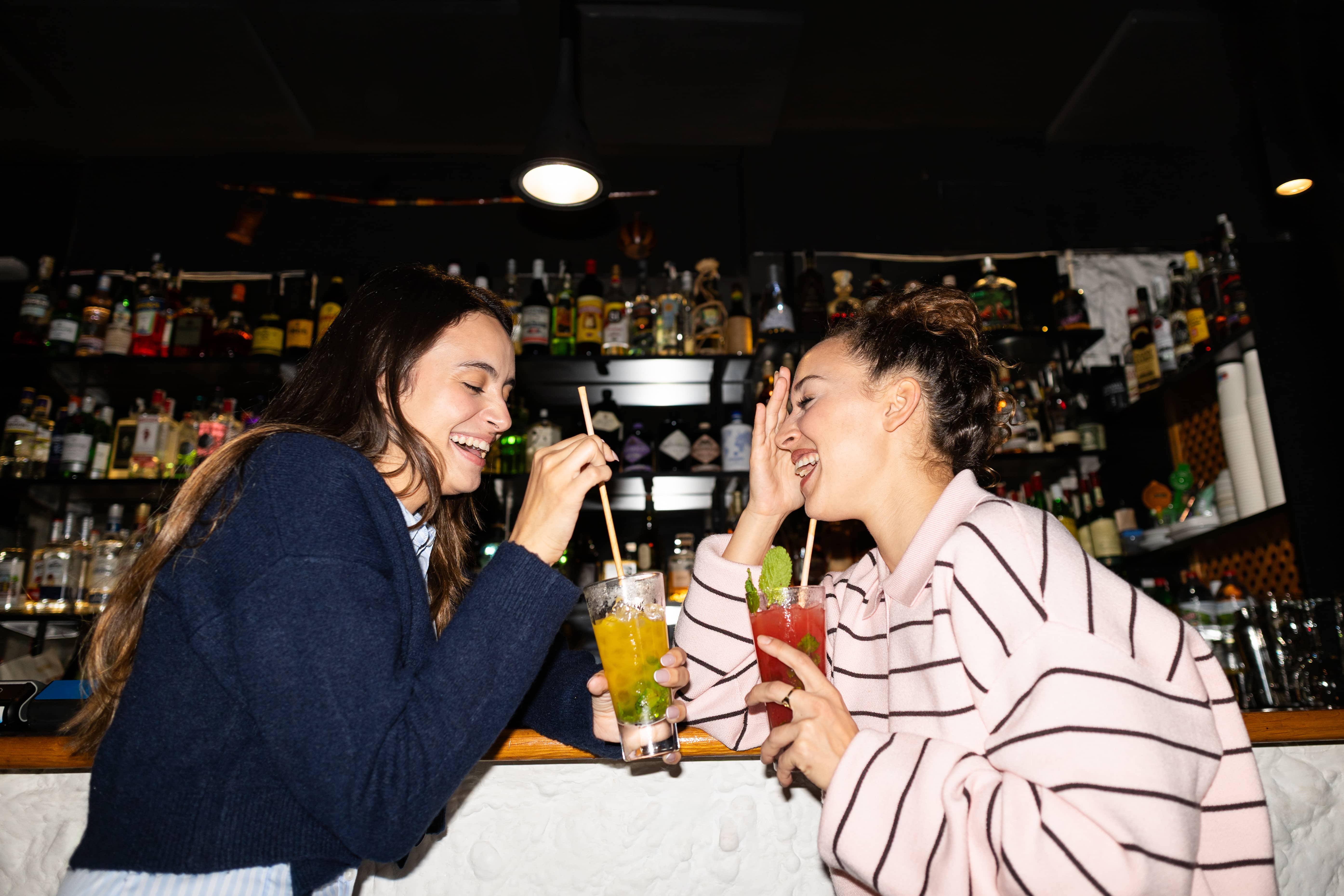 Two people enjoying mocktails at a bar.