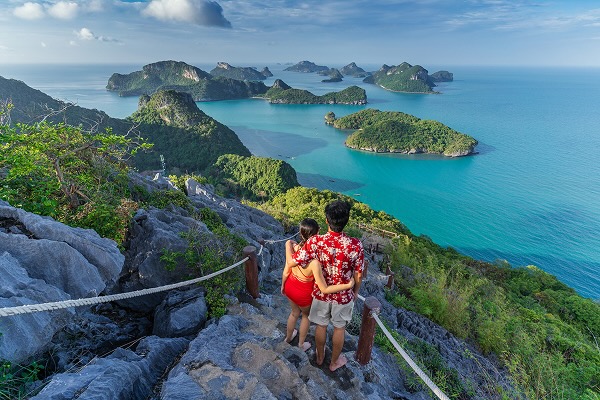 A couple hiking in Hawaii with a picturesque view in the background