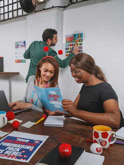 Office workers reading a Red Nose Day fundraising pack