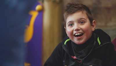 A boy smiling and looking excited.