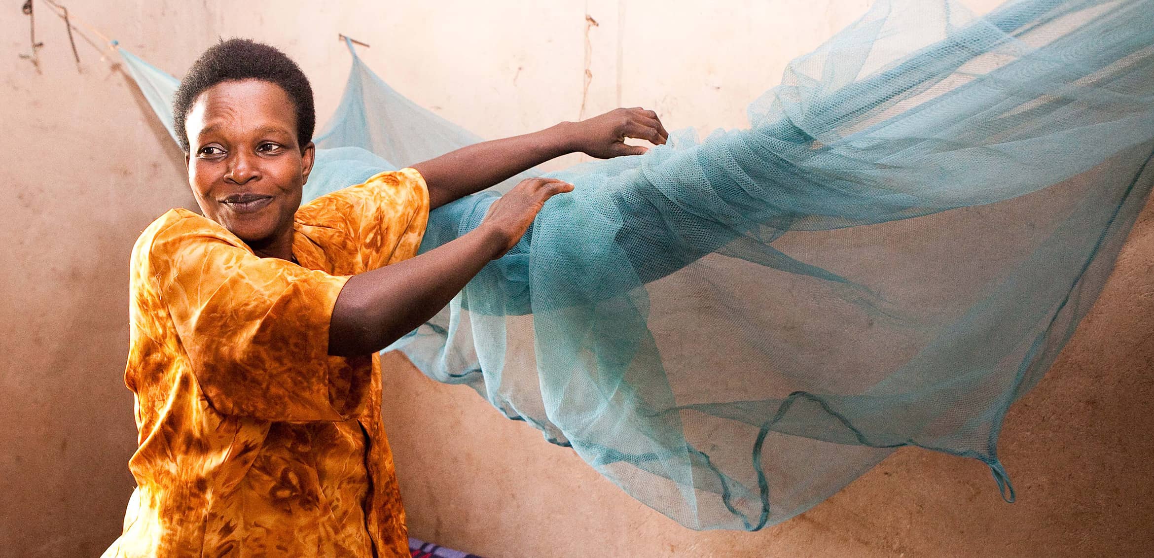A woman putting up a mosquito net.